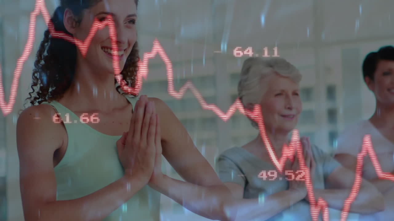 Yoga students practicing namaste in bright studio, overlaying red stock graphs showing finance data