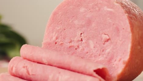 ham italian mordatella, man slices of traditional italian antipasti mortadella sausage on a wooden cutting board, close up macro of chicken or turkey jamon, fat breakfast dish.