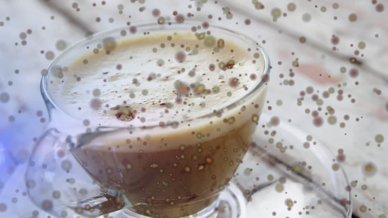 On start coffee cup resting on saucer atop table while colored dots drifting to highlight foam
