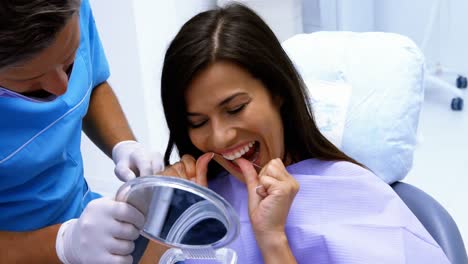 paciente que se limpia los dientes con hilo dental