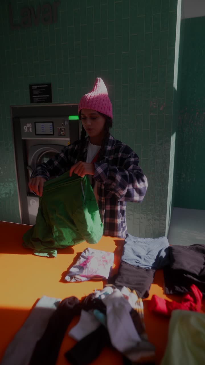 Donna che fa il bucato in una lavanderia a gettoni
