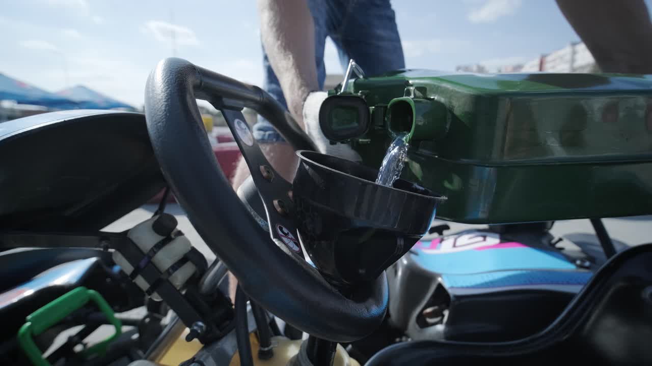 Il meccanico go kart racing service versa benzina nel serbatoio
