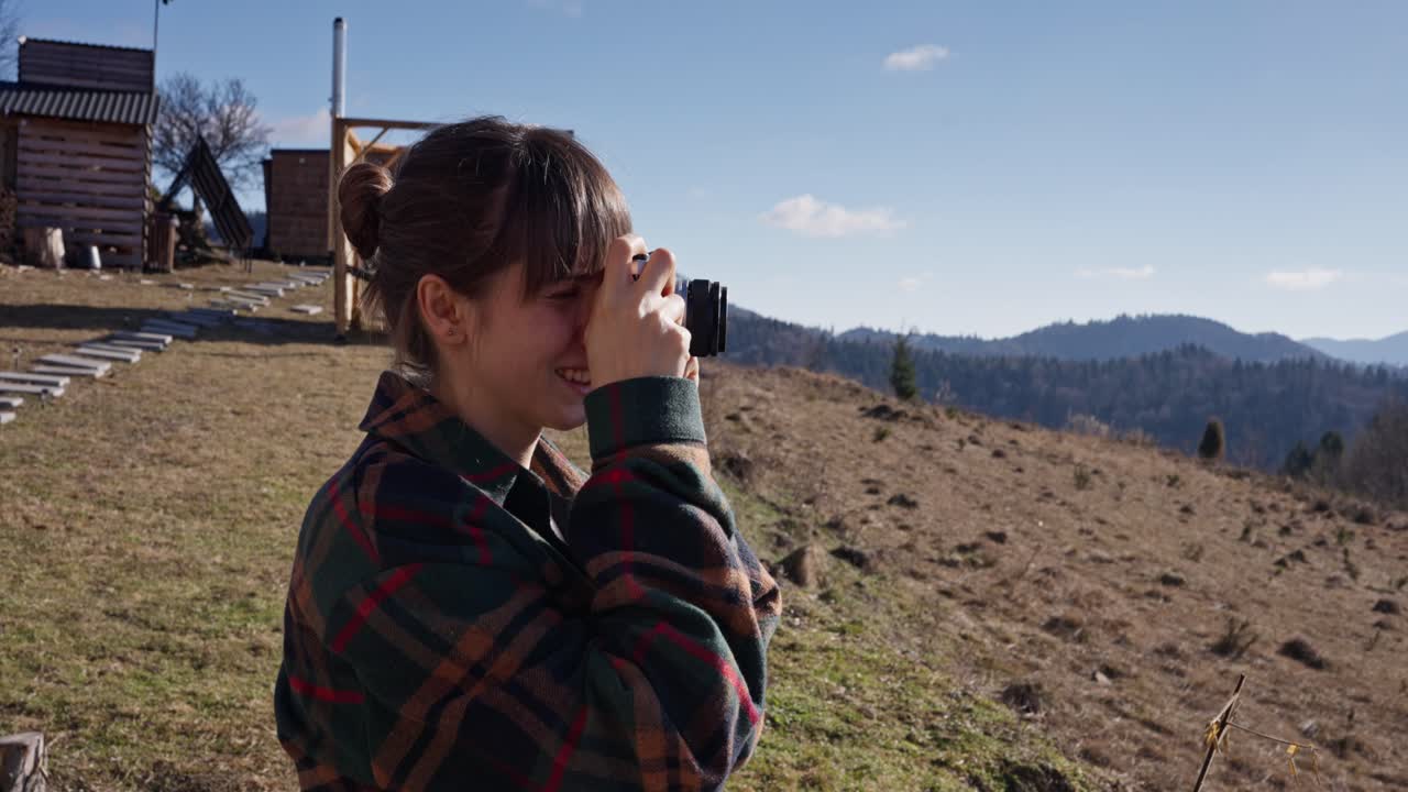 A woman taking photos in the mountains