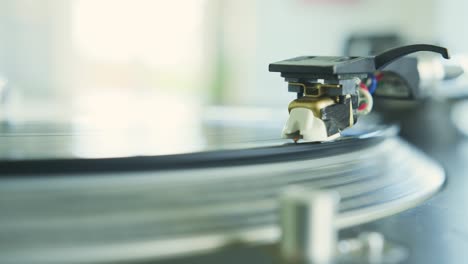 closeup of hand placing stylus needle on record player