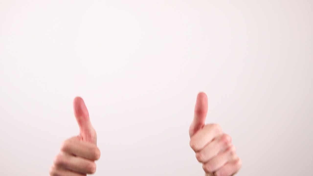 filmó un video de dos manos, con los pulgares hacia arriba, en el marco y saliendo del marco