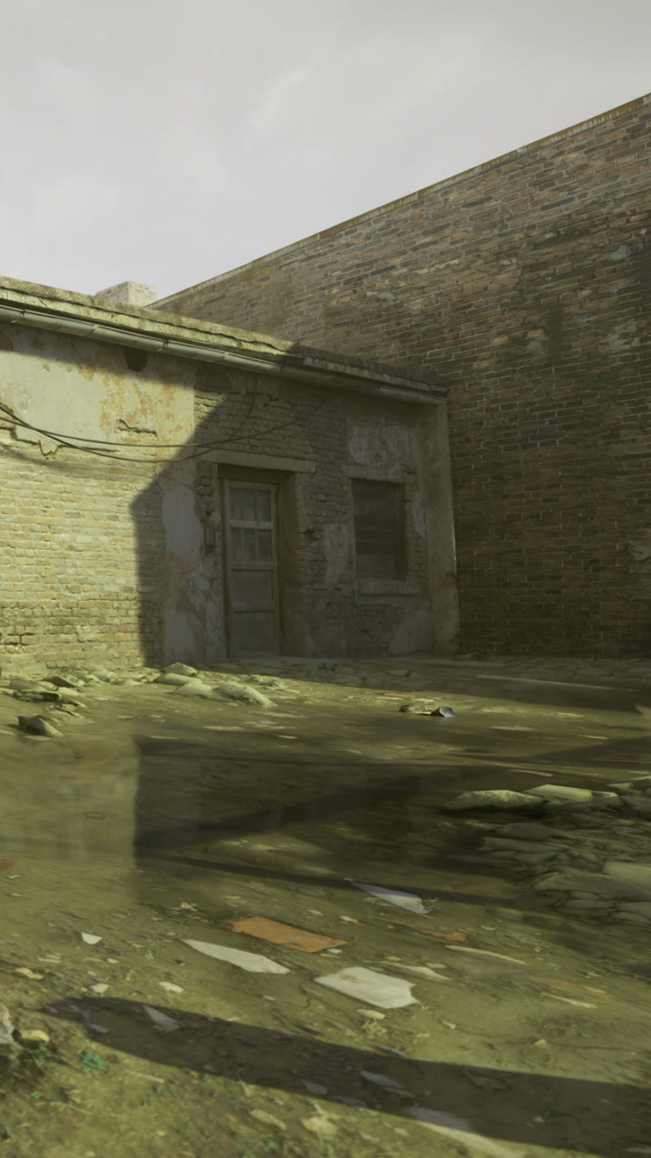 Old building with wet ground near a brick wall in a quiet area during day