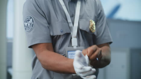 el guardia de seguridad se pone los guantes.
