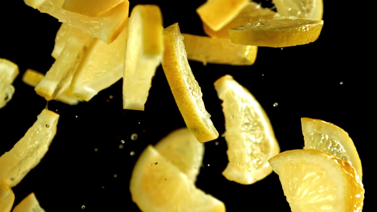 Fresh Lemon Slices Falling in Slow Motion on Black Background