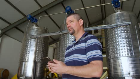 male worker using digital tablet in distillery 4k