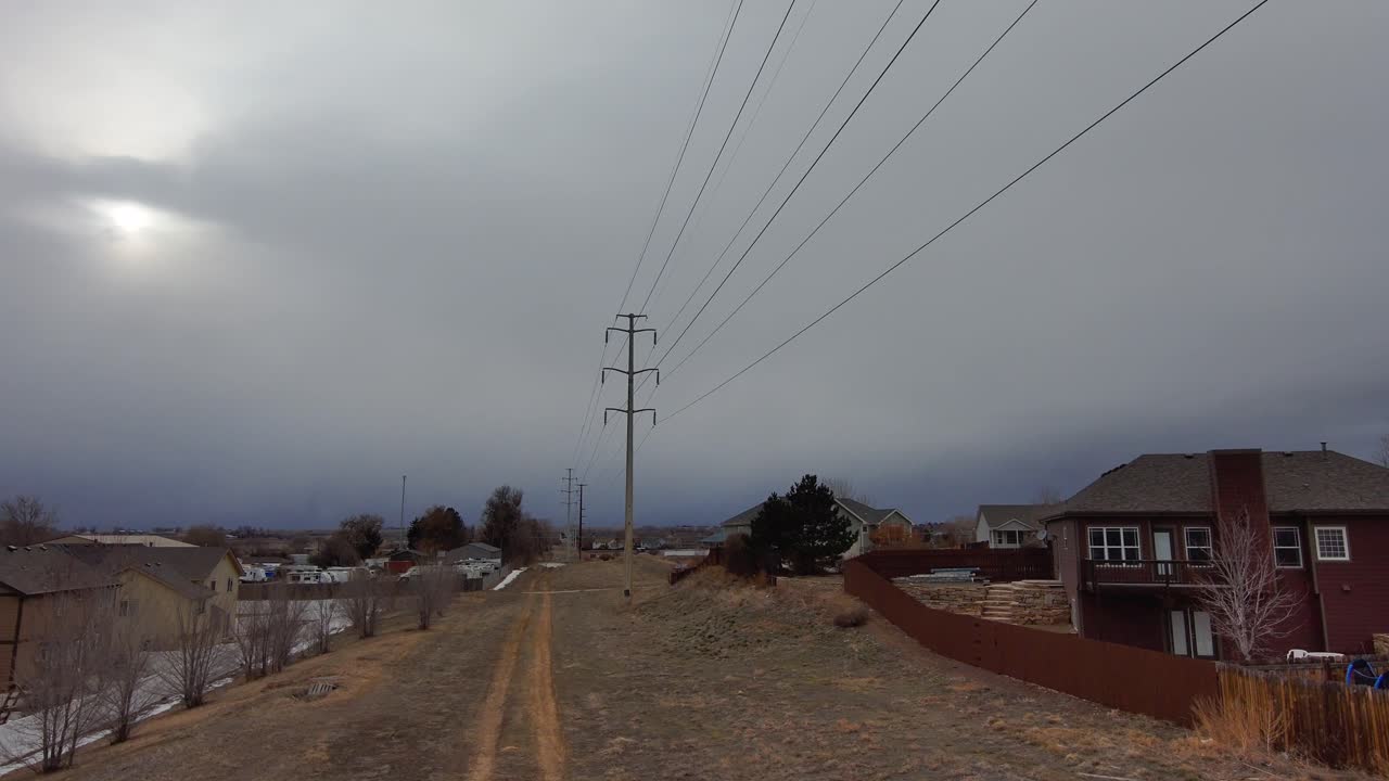 Road to sky pan upward as the drone flies toward a dark sky under high voltage power lines.