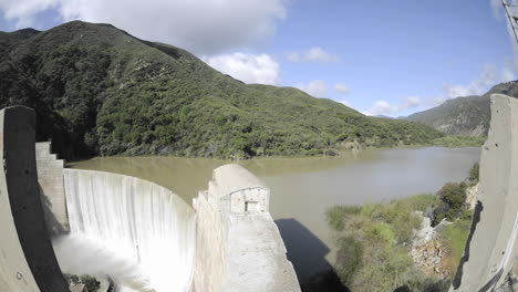 wide time lapse dolly shot from above matilija creek spilling over an obsolete matilija dam 1