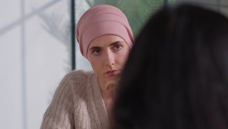 serious young woman patient wearing headscarf undergoing chemotherapy treatment for breast cancer meeting with oncologist or doctor in hospital 1