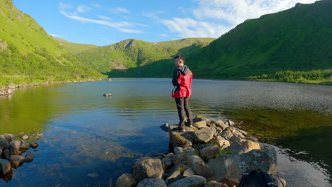 shot-of-a-man-throwing-fishing-rod-into-lake-in-the-summer-at-Vesteralen-Andoya,-Norway