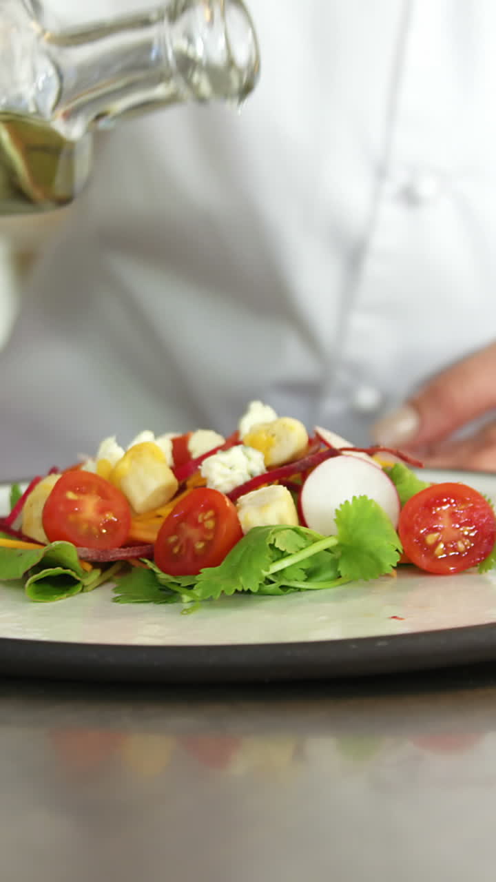 Chef che condisce l'insalata con l'olio