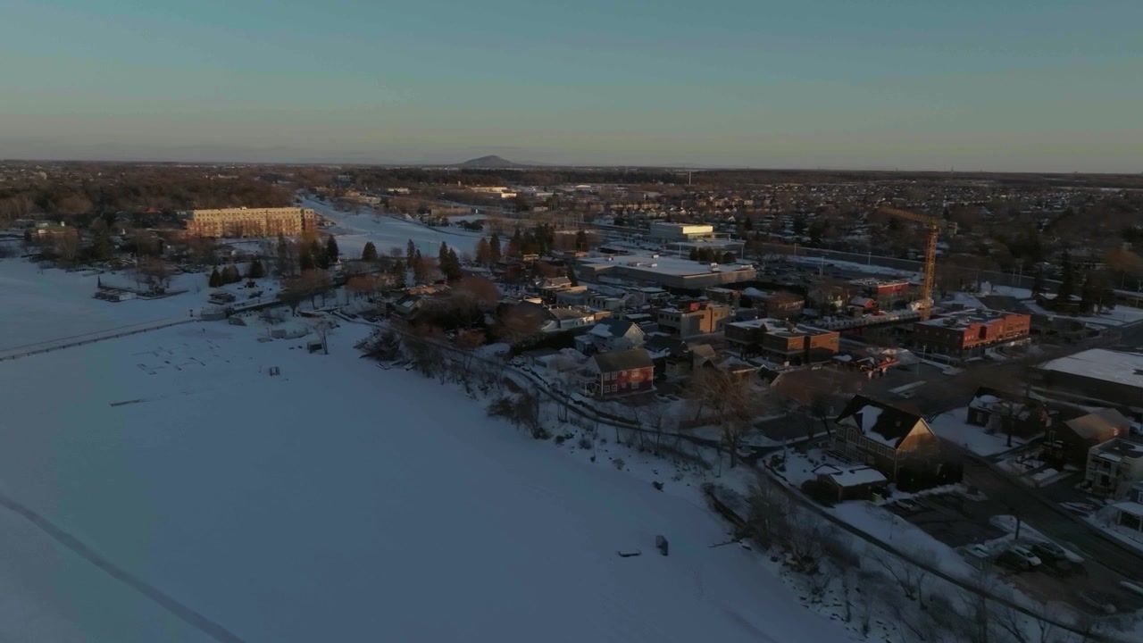 Drone die in de winter over de kustlijn van de Richelieu-rivier vliegt, met uitzicht op de stad Chambly, Quebec, Canada, helemaal tot aan de historische site van het Chambly-kanaal in Canada