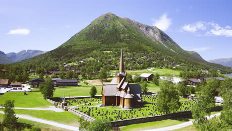 luftaufnahme der stabkirche lom mit grabstein in der nähe des berges und des flusses otta in norwegen