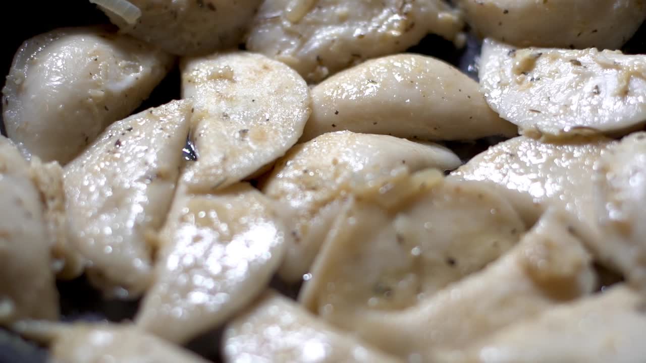 foco lento en rack de pierogies calientes y humeantes que se cocinan en aceite y hierbas