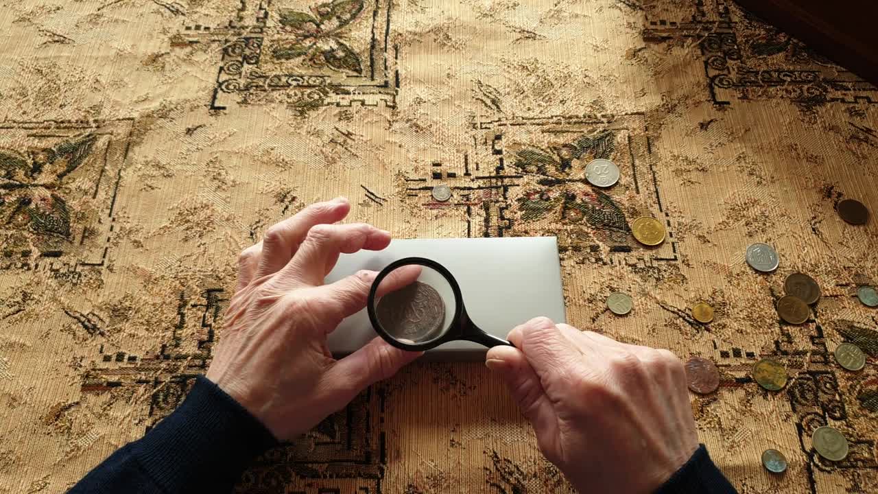 el evaluador de monedas, el coleccionista de monedas. el hombre considera las monedas antiguas.