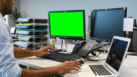 male executive working on laptop and computer