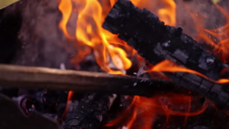 bright bonfire with beautiful sparks. charcoals in vivid flame. combustion of smoldering logs in fire. slow motion.