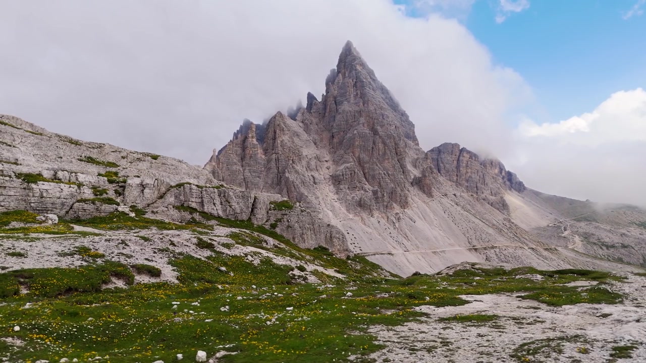 Panoramica aerea verso destra delle Dolomiti con nuvole e bagliore del tramonto in 4K