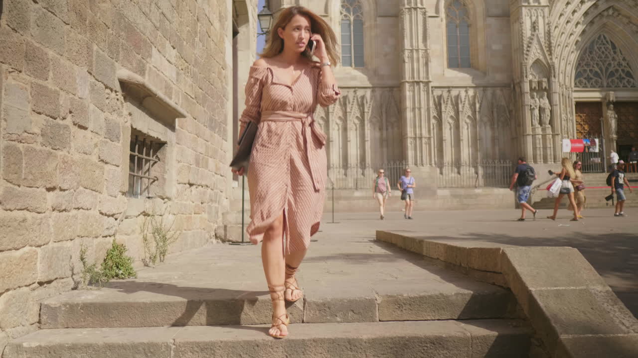 섹시한 여성이  ⁇ 드폰으로 이야기하고 있습니다. 젊은 사업가 여성이 아래층으로 내려가고 있습니다.