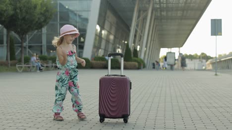 Kind-Mädchen-Tourist-Mit-Koffertasche-In-Der-Nähe-Des-Flughafens.-Kleine-Kinder-Tanzen,-Springen,-Feiern-Mit-Gepäck