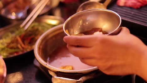 hand serving food into a bowl