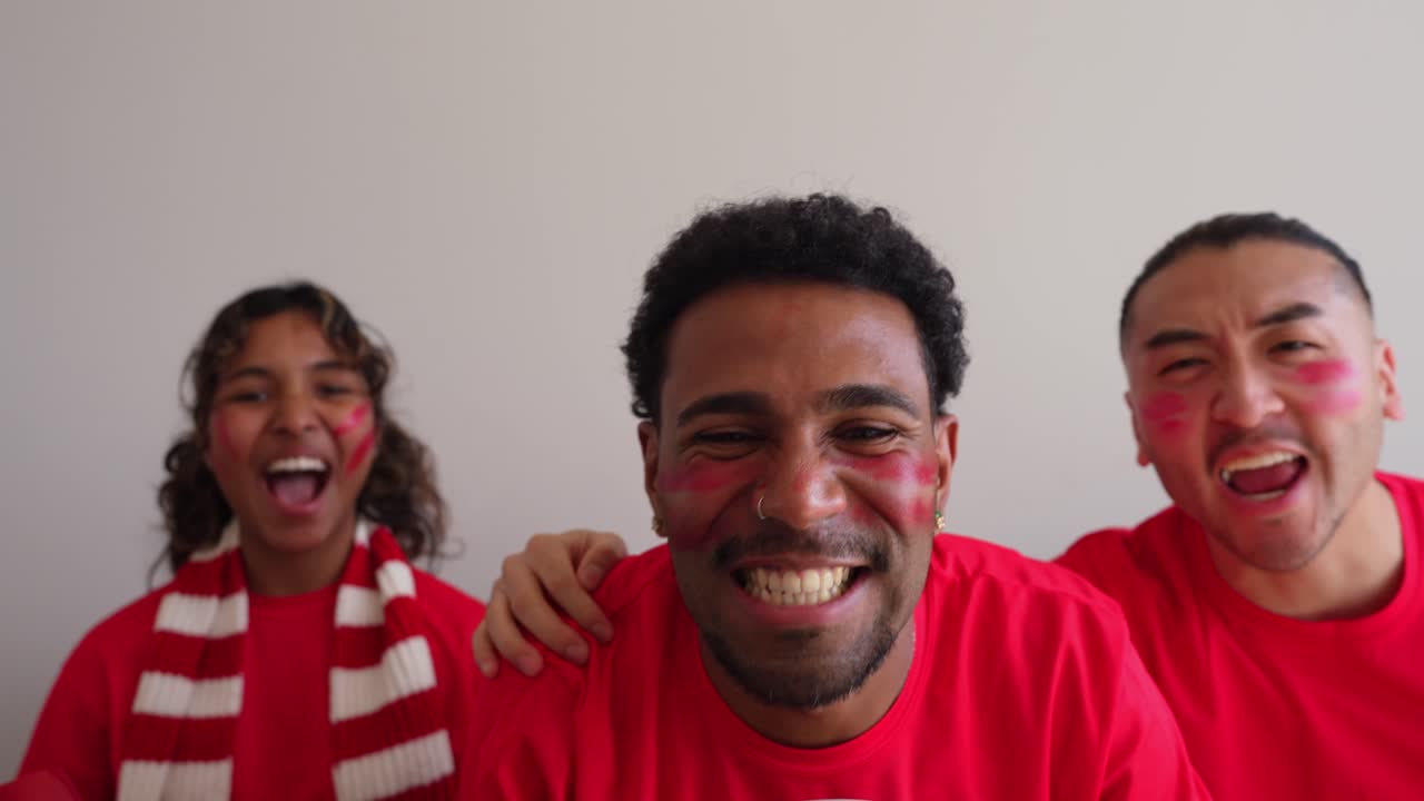 Amici entusiasti che esultano e festeggiano mentre guardano una partita di calcio.