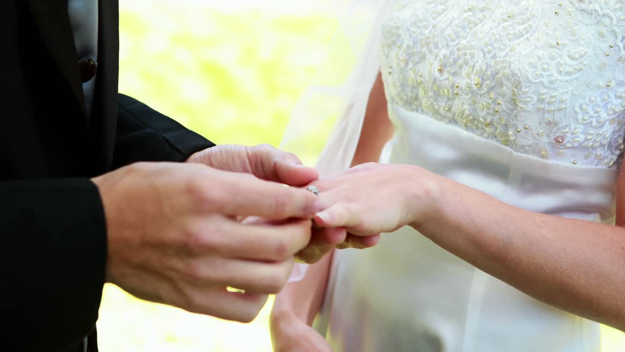 Bride and groom exchanging wedding rings