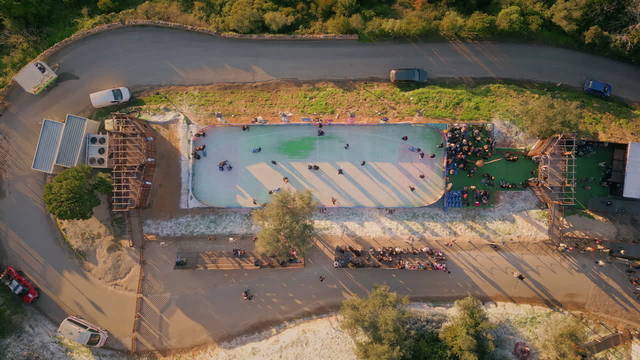Top view people skating on ice rink small  town. Families and children