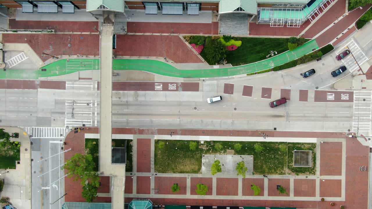 Vista aerea dall'alto con drone, auto sulla strada, marciapiede in mattoni rossi, passerella pedonale sopra la strada, traffico che attraversa l'incrocio