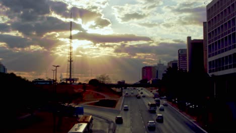 urban traffic at sunset with golden sunbeams shining through the clouds