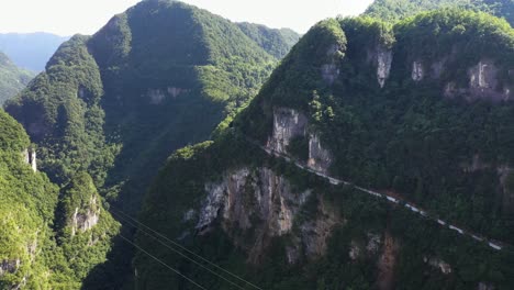 Impresionantes-Imágenes-Aéreas-De-La-Vista-Sobre-La-Carretera-Con-El-Tráfico-Que-Pasa-A-Través-De-Los-Impresionantes-Bosques,-La-Gran-Altitud-Y-Las-Carreteras-Sinuosas,-Capturadas-En-La-Provincia-De-Hebei,-China