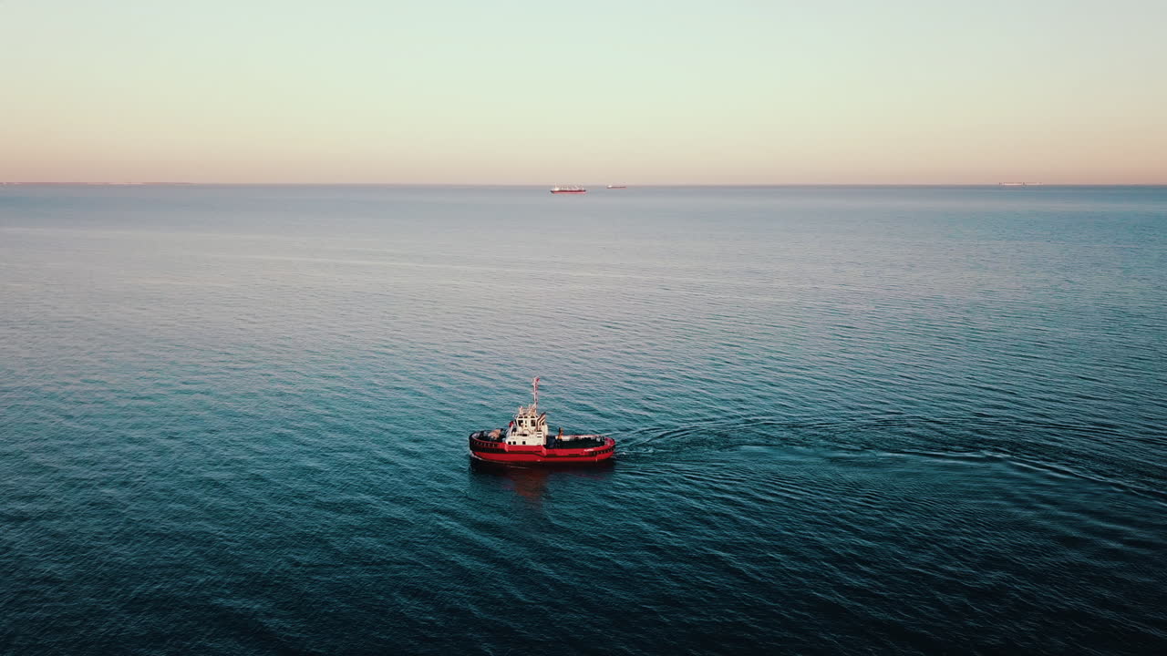 drone volando sobre el barco de pesca navegando en el mar báltico al atardecer