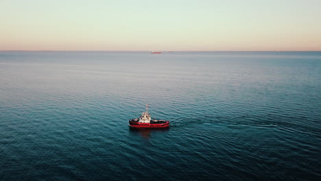 drone flying above the fishing boat sailing on the baltic sea at the sunset