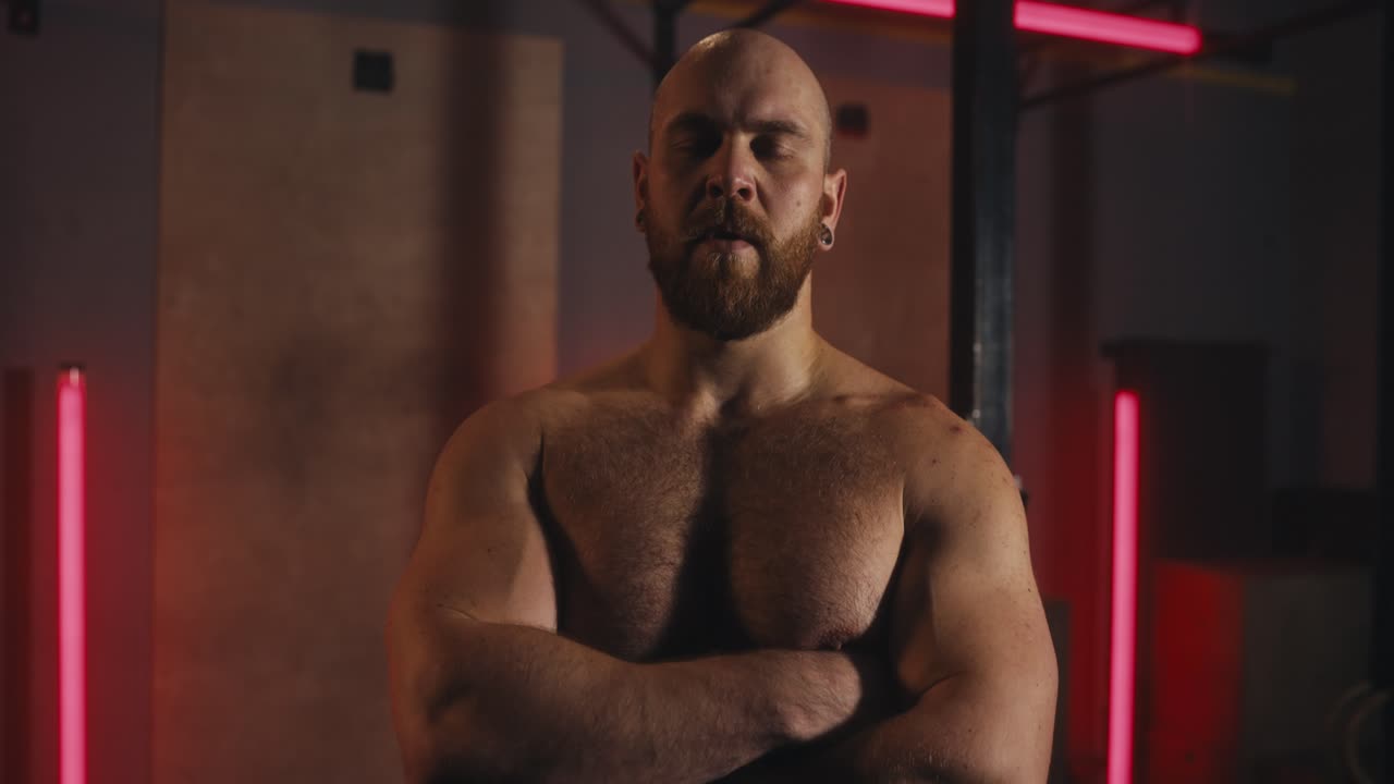 hombre en el gimnasio posando con los brazos cruzados