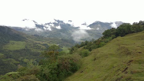 aerial dolly over green rural valley in jardín, colombia, highlighting agricultural fields and mountains