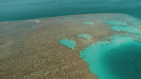aerial shot for the red sea of egypt in the north beside hurghada with the drone moving forward towards a light house on a coral island of abu nuhas coral island