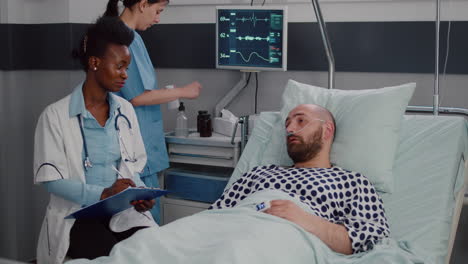 afro american doctor discussing with sick man writing medical treatment