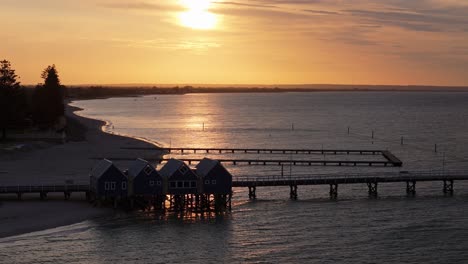 Drone-Captura-La-Puesta-De-Sol-Con-Nubes-Bajas-Contra-El-Embarcadero-De-Busselton-En-El-Río-Margaret,-Australia-Occidental