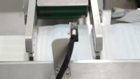 fabricación de máscaras protectoras - máscara que sale de una máquina automática industrial
