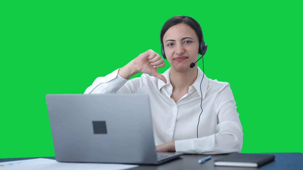 Chica india de centro de llamadas molesta mostrando el pulgar hacia abajo Green screen