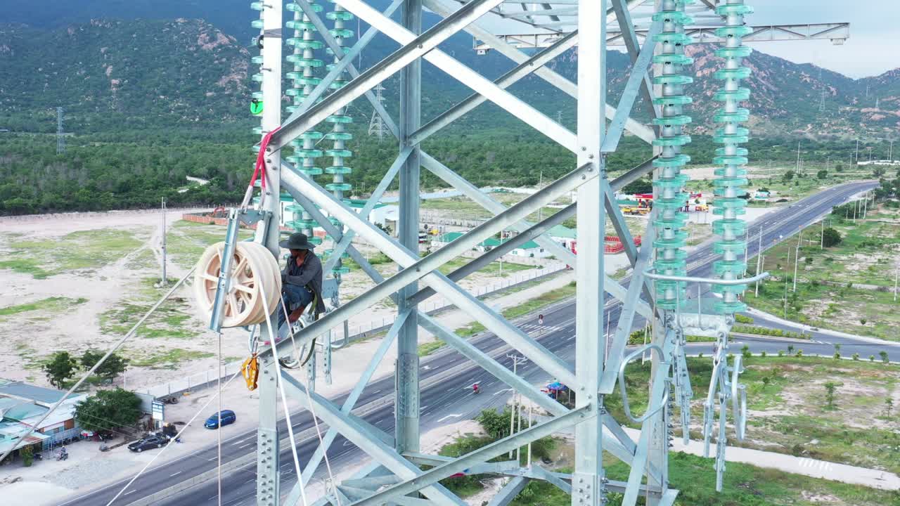 産業公園で電力を配給するためのプレファブリックガラスの隔離器を備えた高圧電力塔のドローン映像 - 開発と都市化コンセプト