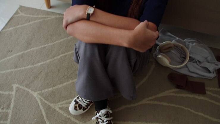 mujer triste sentada en la alfombra