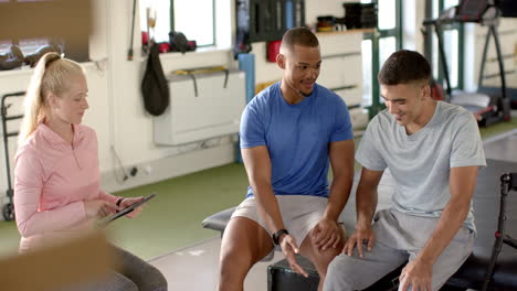 assisting man with disability, therapist team with tablet in rehabilitation center