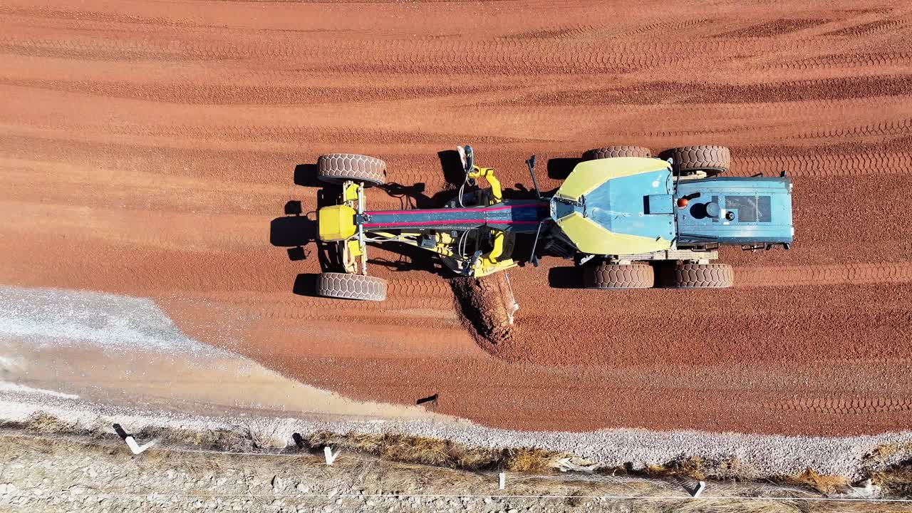 Toma aérea en 4K de una niveladora construyendo una carretera con un dron
