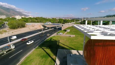 an aerial view of a multi-lane highway with an overpass and city in the background