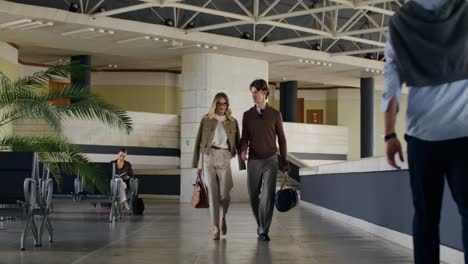 business couple walking through airport terminal
