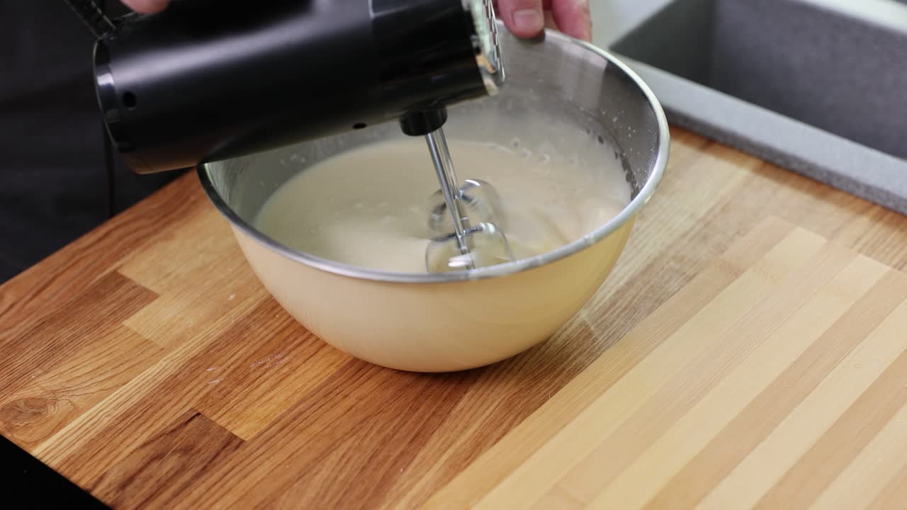Mixing batter with a hand mixer in a bowl